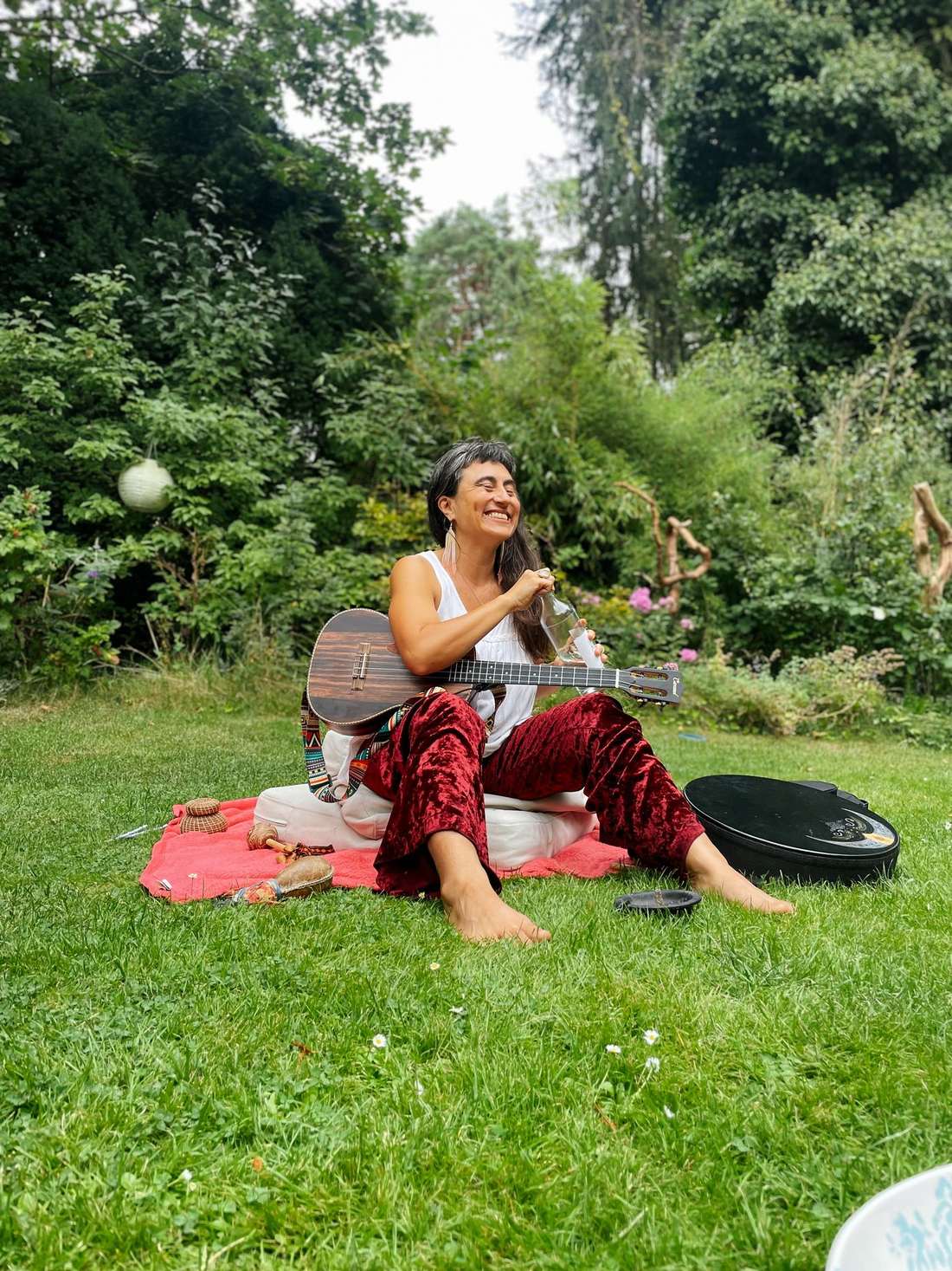 Shaela lachend mit Ukulele im Garten